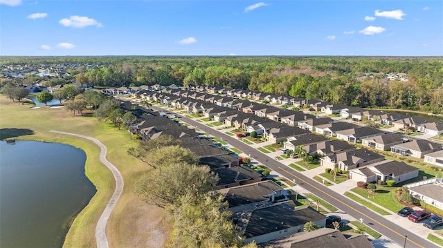 aerial view with a residential view, a view of trees, and a water view