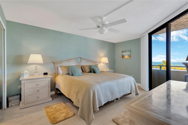 bedroom with light wood finished floors, baseboards, ceiling fan, and access to exterior