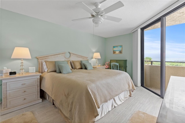 bedroom featuring access to exterior, a ceiling fan, and wood tiled floor