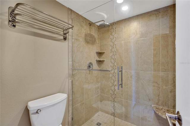 bathroom with a shower stall and toilet