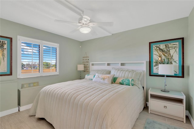 bedroom featuring light wood-style flooring, baseboards, and ceiling fan