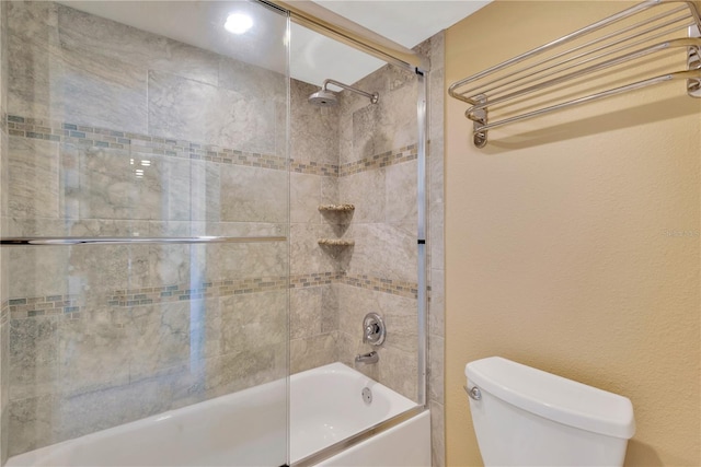 bathroom featuring combined bath / shower with glass door and toilet