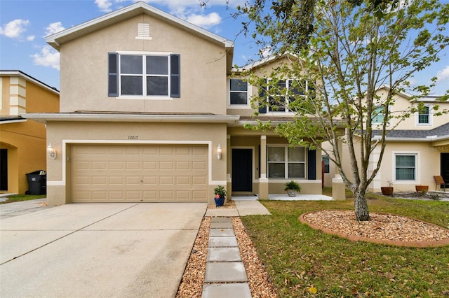 traditional-style house with stucco siding, a garage, concrete driveway, and a front yard