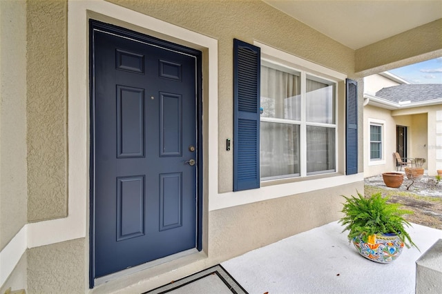 doorway to property featuring stucco siding