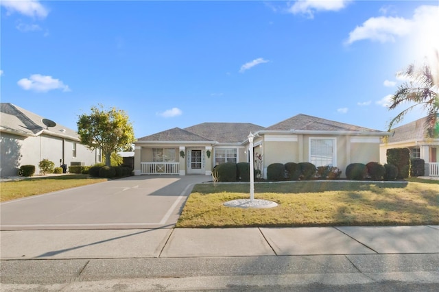 single story home with stucco siding, driveway, and a front yard