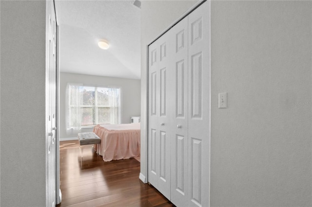 hallway featuring baseboards and dark wood-style floors