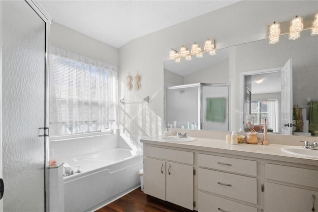 full bathroom with a sink, a garden tub, a stall shower, and double vanity