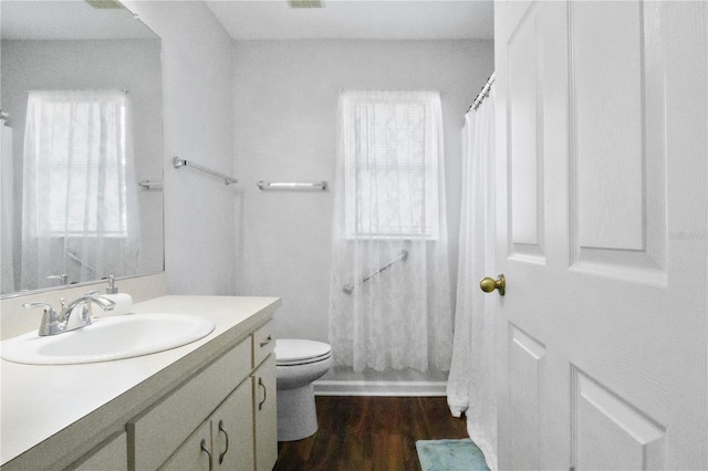 full bath with vanity, toilet, plenty of natural light, and wood finished floors