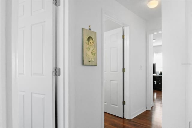 hall with baseboards and dark wood-style flooring