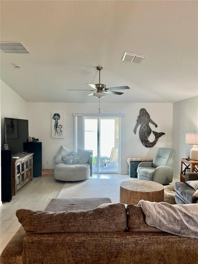 living area with visible vents and ceiling fan