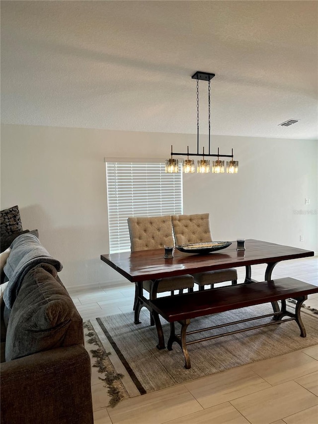 dining space with visible vents and a textured ceiling