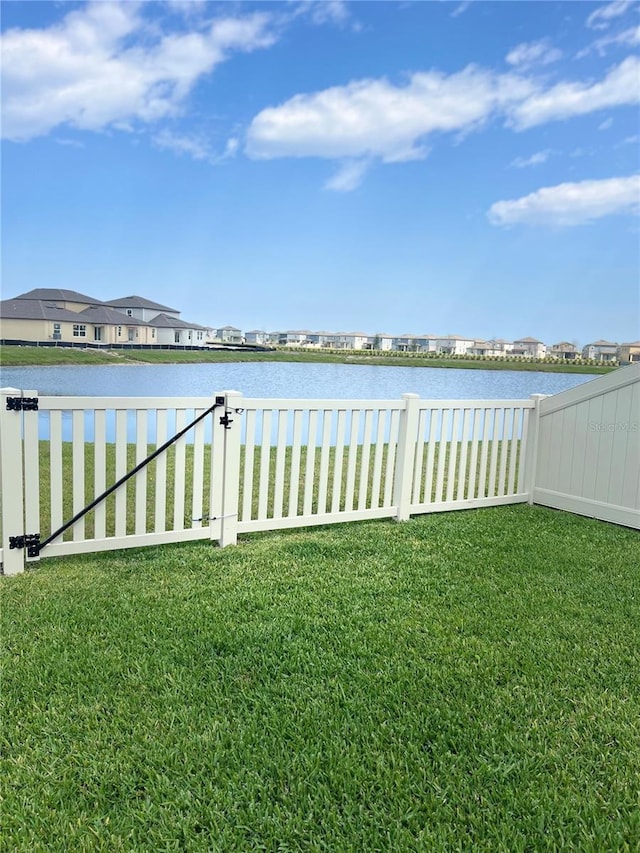 view of yard with fence and a water view