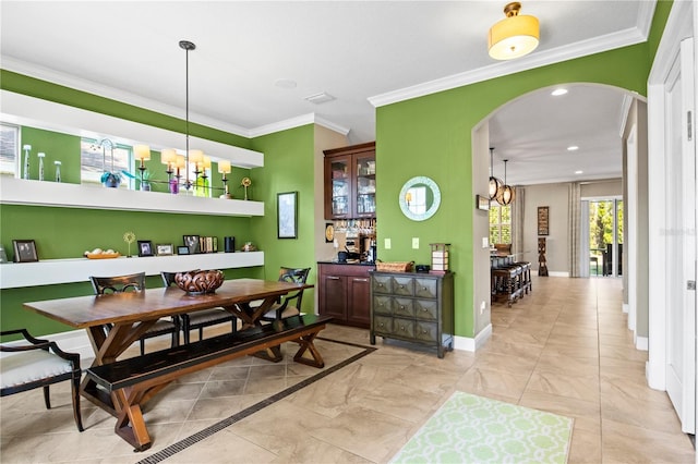 dining room featuring baseboards, recessed lighting, arched walkways, crown molding, and a chandelier