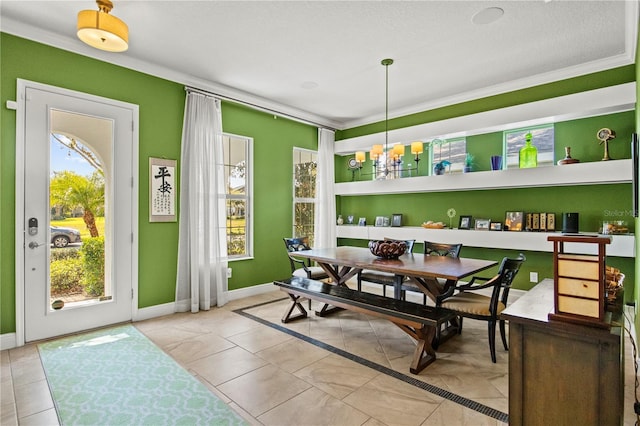 dining space featuring tile patterned flooring, a notable chandelier, crown molding, and baseboards