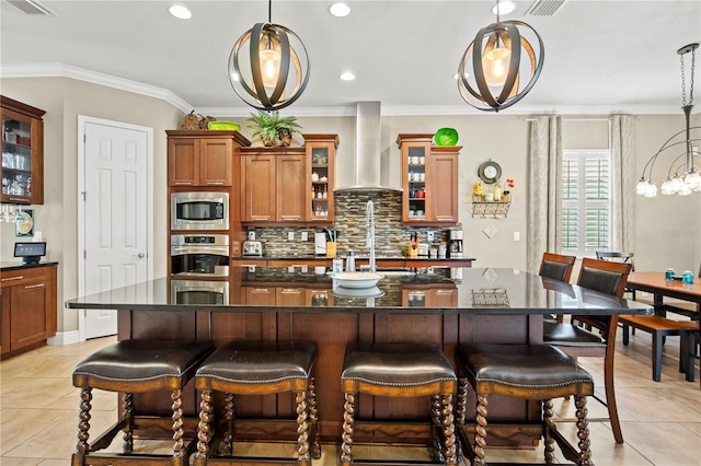 kitchen featuring backsplash, dark countertops, stainless steel appliances, crown molding, and wall chimney range hood