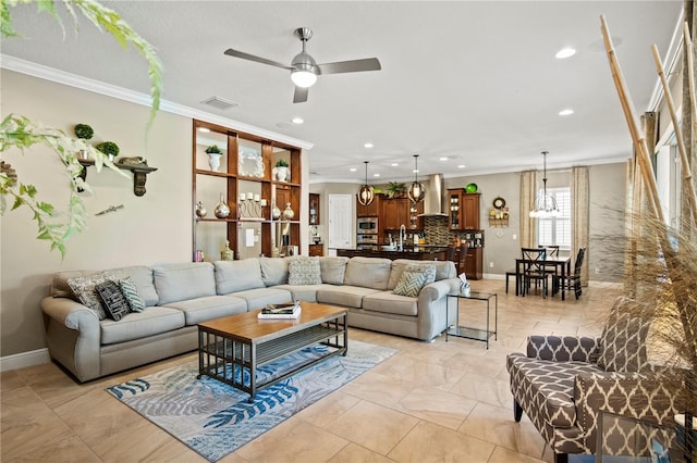 living room featuring visible vents, baseboards, a ceiling fan, and crown molding