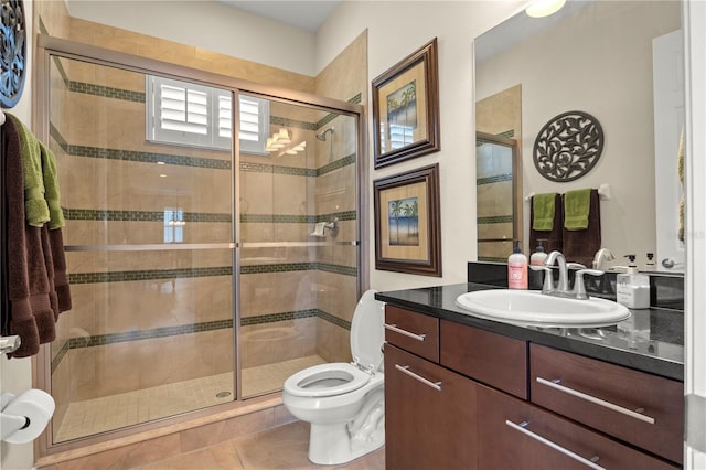 bathroom with vanity, a shower stall, toilet, and tile patterned floors