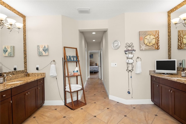 full bathroom with visible vents, ensuite bath, two vanities, a sink, and a notable chandelier