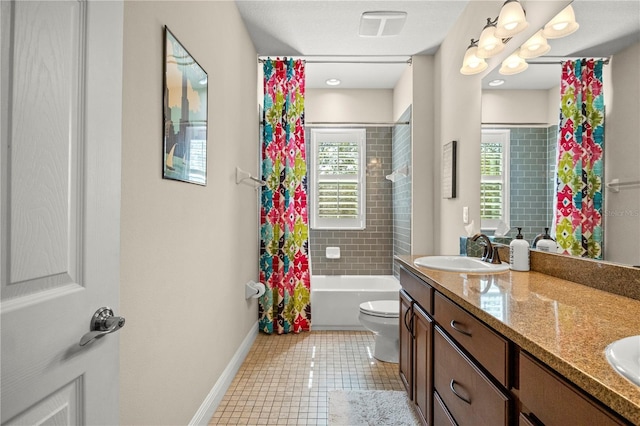 bathroom featuring tile patterned floors, toilet, a sink, double vanity, and baseboards