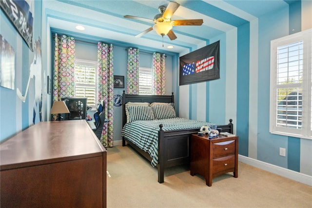 bedroom with light colored carpet, baseboards, and ceiling fan