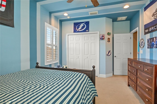 bedroom with baseboards, visible vents, a closet, and light carpet