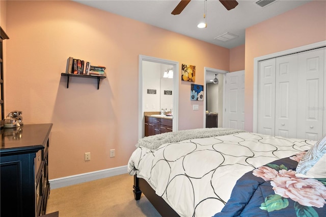 bedroom featuring light carpet, ensuite bathroom, a closet, baseboards, and ceiling fan