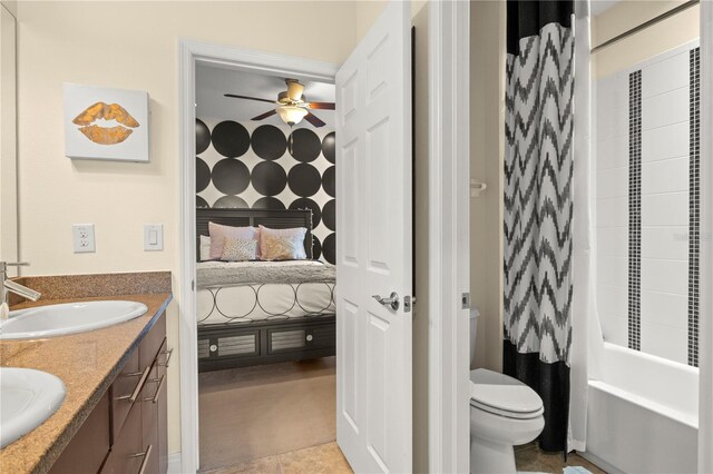 bathroom featuring toilet, a ceiling fan, a sink, ensuite bath, and double vanity