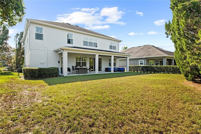 back of house featuring stucco siding, a lawn, a patio area, and fence