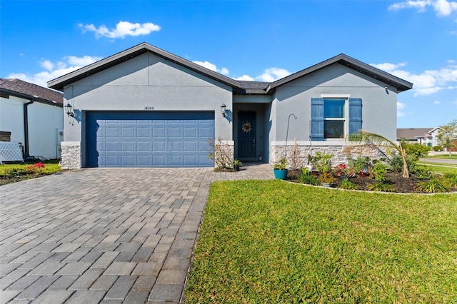 single story home featuring stone siding, an attached garage, decorative driveway, and a front yard