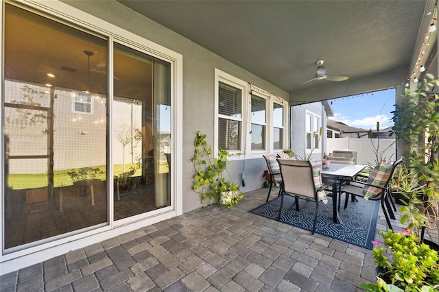 sunroom / solarium featuring a ceiling fan