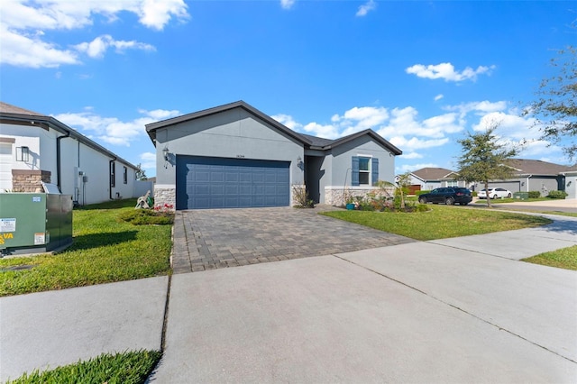 single story home featuring stone siding, an attached garage, decorative driveway, and a front lawn