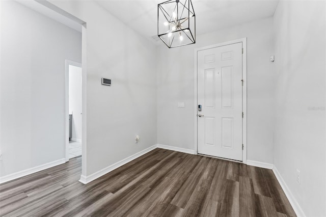 foyer featuring baseboards and dark wood-type flooring