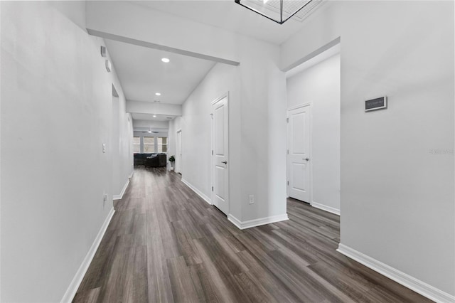 hall with recessed lighting, visible vents, baseboards, and dark wood-style floors