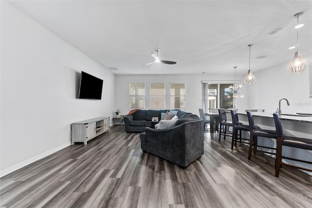 living area featuring visible vents, baseboards, and dark wood finished floors