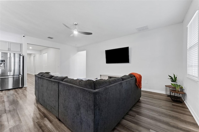 living area featuring visible vents, dark wood-style floors, and a ceiling fan