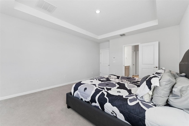 bedroom with visible vents, a raised ceiling, and carpet floors