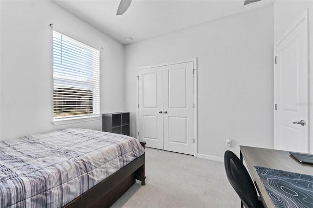 bedroom featuring light carpet, a closet, baseboards, and a ceiling fan