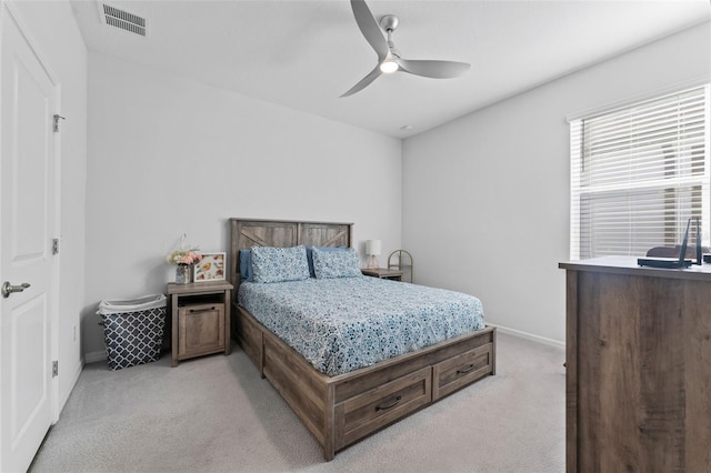 bedroom featuring visible vents, baseboards, light colored carpet, and a ceiling fan