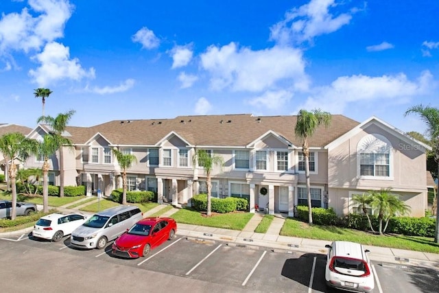 view of building exterior with a residential view and uncovered parking