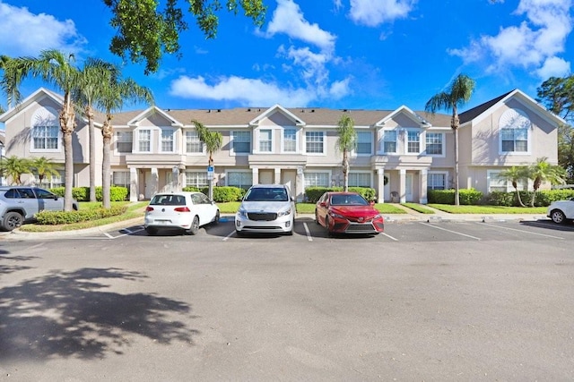 view of building exterior featuring uncovered parking and a residential view