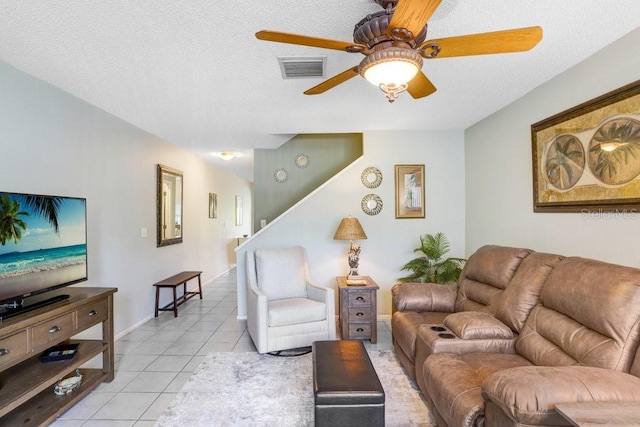 living area with stairway, light tile patterned floors, a ceiling fan, visible vents, and a textured ceiling