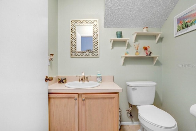 bathroom with a textured ceiling, vanity, and toilet