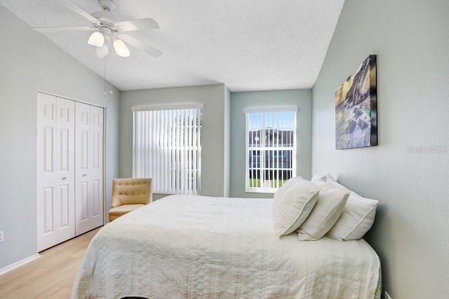 bedroom with a closet, light wood-style flooring, a textured ceiling, and ceiling fan