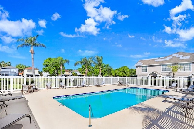 pool featuring fence and a patio area