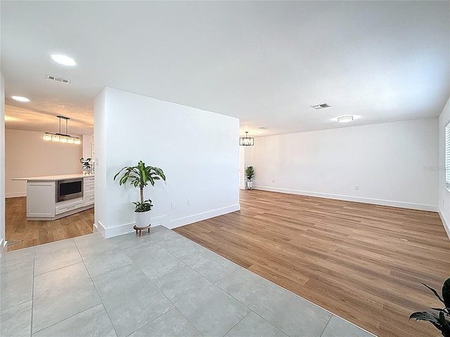 interior space featuring baseboards, visible vents, and light wood finished floors