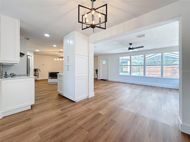 kitchen featuring visible vents, white cabinetry, and light wood-style floors