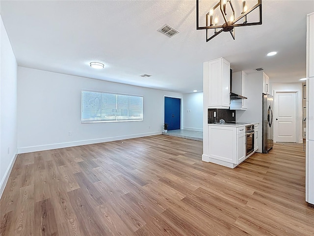 kitchen with light wood-type flooring, visible vents, appliances with stainless steel finishes, and open floor plan