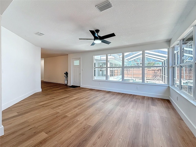 unfurnished living room with wood finished floors, visible vents, and baseboards