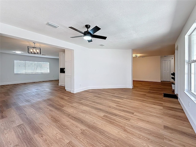 spare room with visible vents, baseboards, a textured ceiling, and light wood finished floors