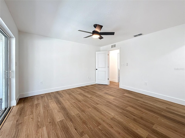 unfurnished bedroom with visible vents, baseboards, and wood finished floors